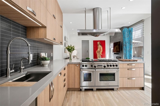 kitchen with light brown cabinets, ventilation hood, modern cabinets, and range with two ovens
