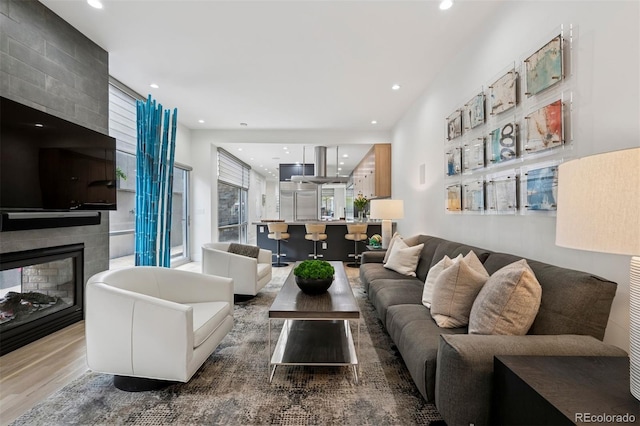 living area with recessed lighting, wood finished floors, and a healthy amount of sunlight