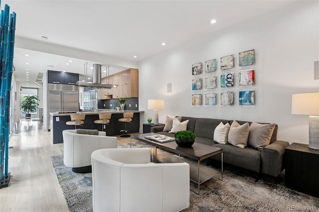 living area with recessed lighting and light wood finished floors