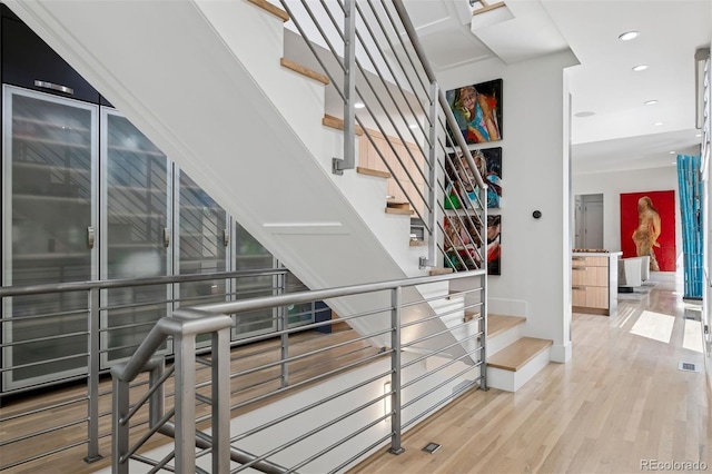 stairway featuring recessed lighting, baseboards, and wood finished floors