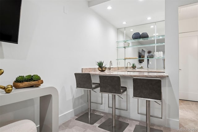 bar featuring baseboards, light carpet, and recessed lighting