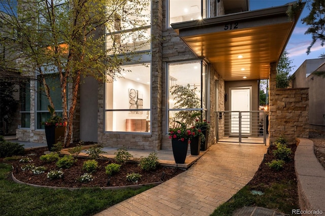 view of exterior entry with a porch and stone siding