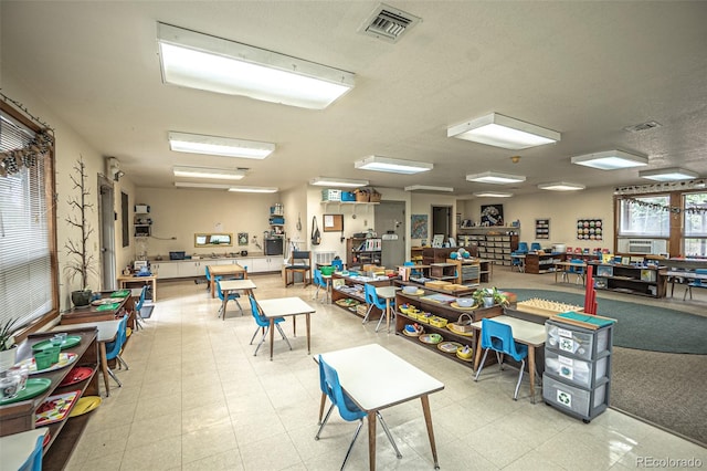 misc room with light tile patterned flooring and a textured ceiling