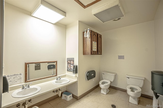 bathroom featuring tile patterned flooring, double sink vanity, toilet, and a bidet