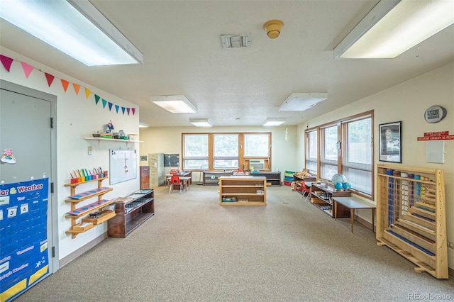 recreation room featuring carpet floors and a textured ceiling