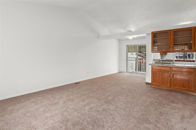 12116 N Fairfax St, Thornton, CO 80241 - kitchen featuring baseboards, light colored carpet, brown cabinetry, and glass insert cabinets