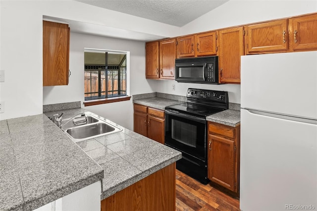 12116 N Fairfax St, Thornton, CO 80241 - kitchen with a peninsula, a sink, brown cabinetry, black appliances, and tile countertops