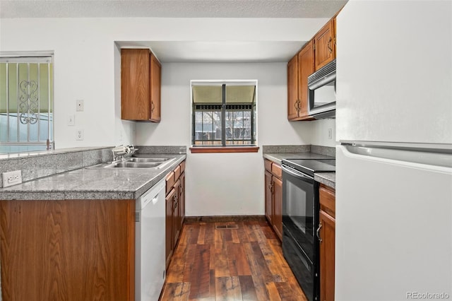 12116 N Fairfax St, Thornton, CO 80241 - kitchen featuring a sink, brown cabinetry, white appliances, dark wood-style flooring, and baseboards