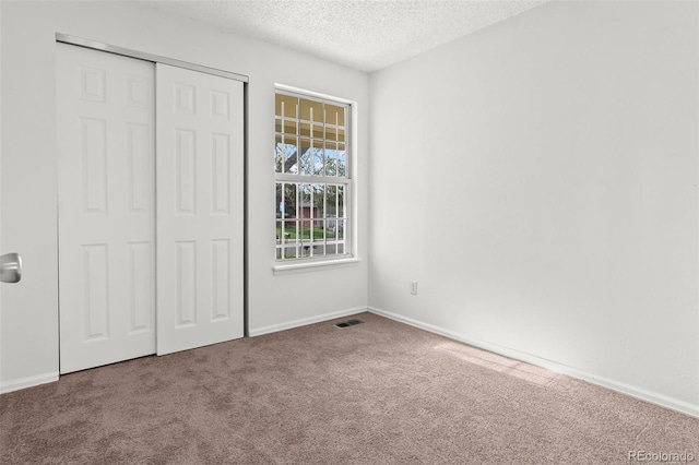 12116 N Fairfax St, Thornton, CO 80241 - unfurnished bedroom with a closet, a textured ceiling, baseboards, visible vents, and carpet floors