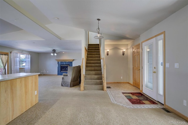 11577 Cranston Dr, Peyton, CO 80831 - entryway featuring light colored carpet, stairway, a premium fireplace, lofted ceiling, and baseboards