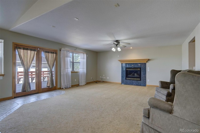 11577 Cranston Dr, Peyton, CO 80831 - unfurnished living room with a ceiling fan, baseboards, a tiled fireplace, and light colored carpet