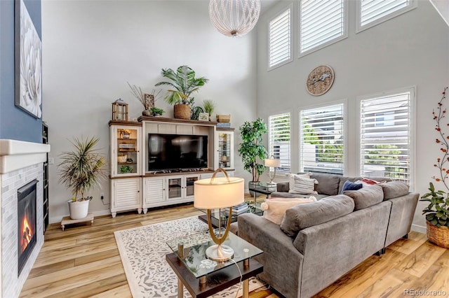 21658 E Tallkid Ave, Parker, CO 80138 - living room featuring wood finished floors, a glass covered fireplace, and a high ceiling