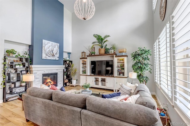 21658 E Tallkid Ave, Parker, CO 80138 - living area with a high ceiling, wood finished floors, and a glass covered fireplace