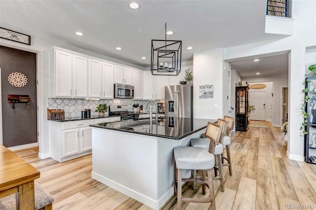 21658 E Tallkid Ave, Parker, CO 80138 - kitchen with appliances with stainless steel finishes, white cabinets, light wood-type flooring, backsplash, and recessed lighting