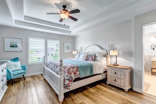 21658 E Tallkid Ave, Parker, CO 80138 - bedroom featuring a raised ceiling, light wood finished floors, a ceiling fan, and ensuite bathroom