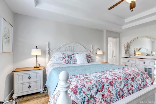 21658 E Tallkid Ave, Parker, CO 80138 - bedroom with light wood finished floors, a tray ceiling, and ceiling fan