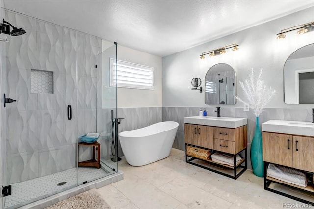 21658 E Tallkid Ave, Parker, CO 80138 - full bathroom with a stall shower, tile walls, a freestanding tub, two vanities, and wainscoting