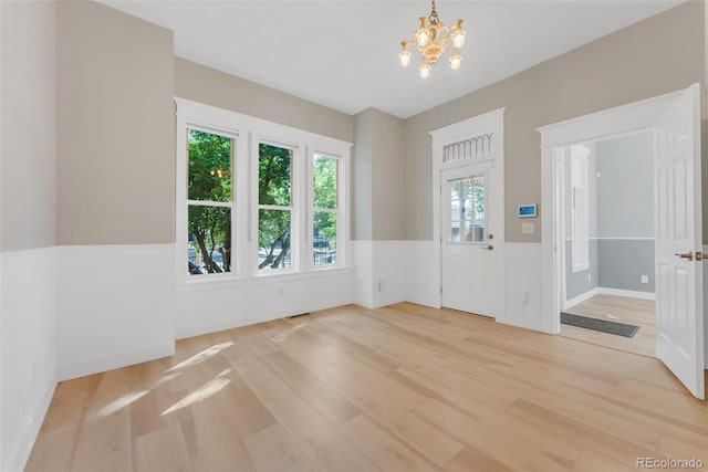 2323 W Pikes Peak Ave, Colorado Springs, CO 80904 - foyer featuring light wood-style flooring, a chandelier, and a wainscoted wall