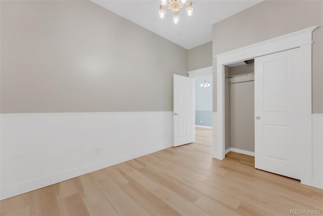 2323 W Pikes Peak Ave, Colorado Springs, CO 80904 - unfurnished bedroom featuring a chandelier, light wood-style floors, and a closet