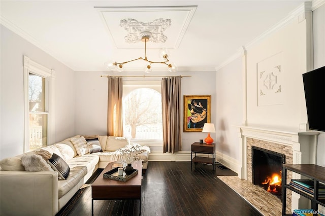 living room with dark wood-style flooring, a fireplace, crown molding, and baseboards