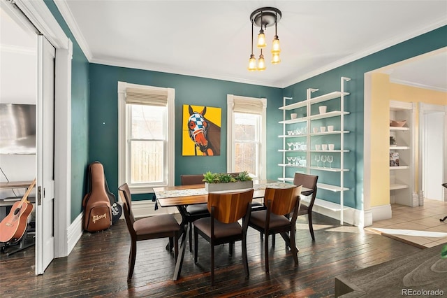 dining space with a chandelier, hardwood / wood-style floors, baseboards, and crown molding