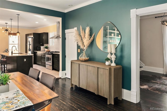 dining room with ornamental molding, baseboards, and wood finished floors