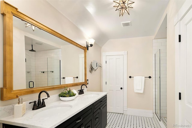 bathroom featuring double vanity, a shower stall, visible vents, and a sink