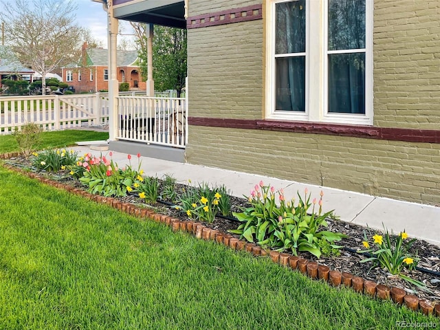 view of side of home with brick siding and a yard