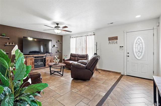 1419 Swan Ave, Brighton, CO 80601 - living area with ceiling fan, baseboards, a textured ceiling, and stone tile floors