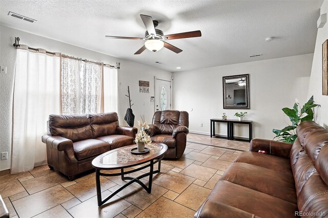 1419 Swan Ave, Brighton, CO 80601 - living room featuring ceiling fan, baseboards, a textured ceiling, and stone tile floors