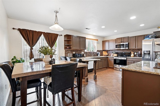 1419 Swan Ave, Brighton, CO 80601 - kitchen with stainless steel appliances, a sink, backsplash, open shelves, and recessed lighting