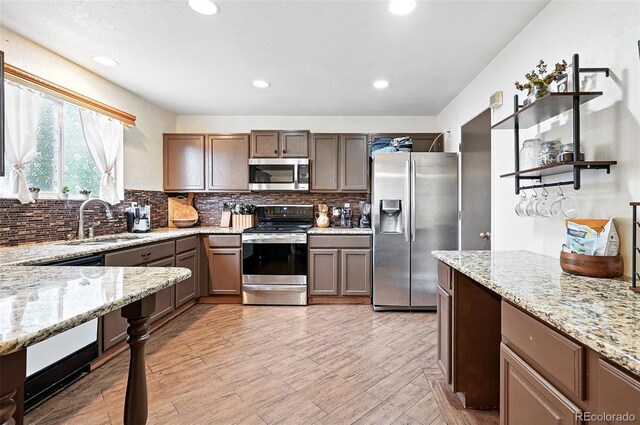1419 Swan Ave, Brighton, CO 80601 - kitchen featuring stainless steel appliances, a sink, tasteful backsplash, light stone countertops, and recessed lighting