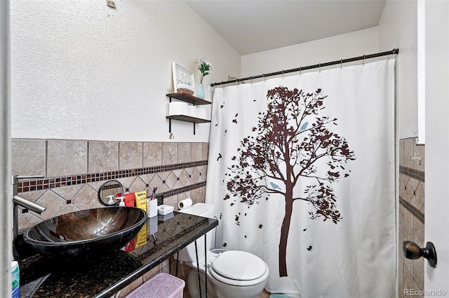 1419 Swan Ave, Brighton, CO 80601 - bathroom with toilet, tile walls, a shower with curtain, and wainscoting