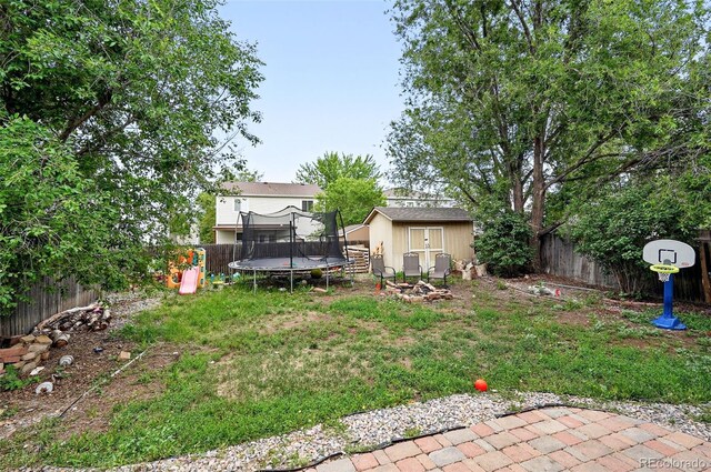 1419 Swan Ave, Brighton, CO 80601 - view of yard featuring a trampoline and an outdoor fire pit