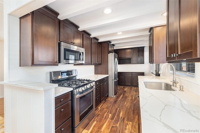 kitchen featuring light stone counters, appliances with stainless steel finishes, sink, dark hardwood / wood-style flooring, and beam ceiling