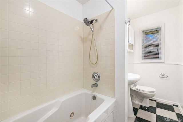 bathroom featuring tile flooring, tiled shower / bath combo, and toilet