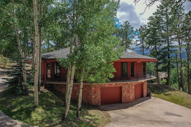 1000 Ponderosa Way, Woodland Park, CO 80863 - view of front facade featuring roof with shingles, stone siding, and concrete driveway