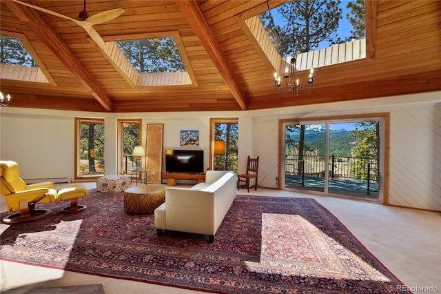 1000 Ponderosa Way, Woodland Park, CO 80863 - carpeted living area with a chandelier, a skylight, plenty of natural light, wood walls, and a wood ceiling with exposed beams