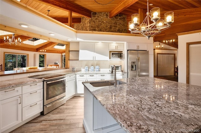 1000 Ponderosa Way, Woodland Park, CO 80863 - kitchen with stainless steel appliances, a chandelier, a wood ceiling with exposed beams, light wood-type flooring, and white cabinetry