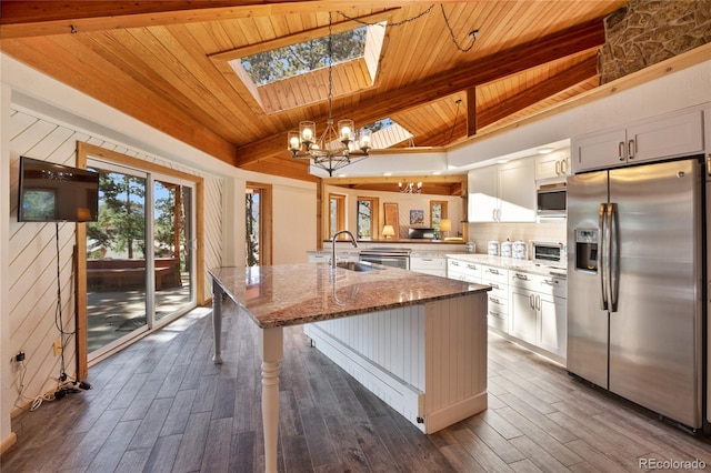 1000 Ponderosa Way, Woodland Park, CO 80863 - kitchen with stainless steel appliances, a skylight, wood ceiling, a chandelier, and stone counters