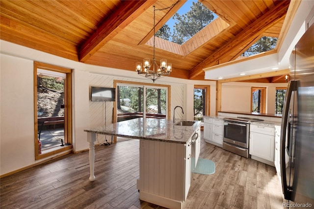 1000 Ponderosa Way, Woodland Park, CO 80863 - kitchen featuring stainless steel electric range, freestanding refrigerator, a wooden ceiling with exposed beams, a chandelier, and light wood-type flooring