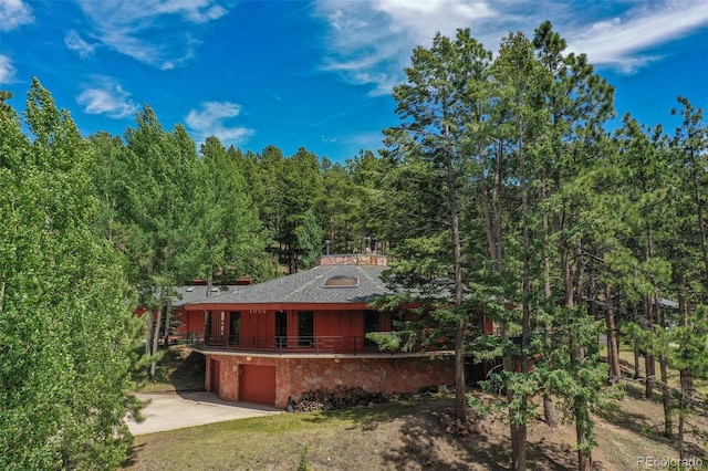 1000 Ponderosa Way, Woodland Park, CO 80863 - view of front of property featuring a garage, driveway, a forest view, and a shingled roof