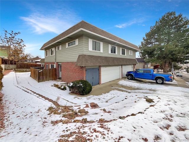 snow covered property featuring a garage