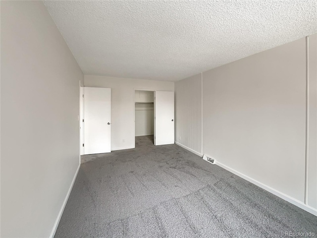 unfurnished bedroom featuring dark carpet, a closet, and a textured ceiling