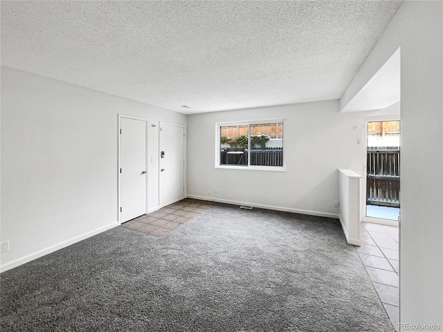 unfurnished room with carpet floors and a textured ceiling