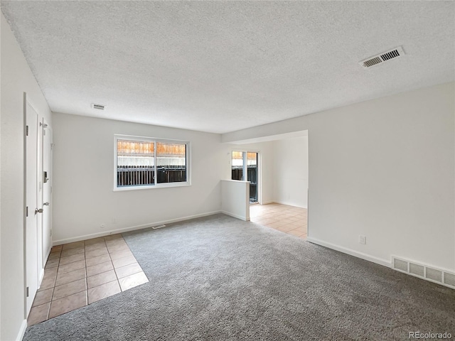 carpeted empty room with a textured ceiling