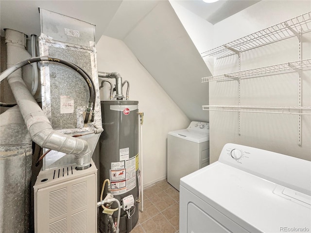 clothes washing area featuring light tile patterned flooring, washer and dryer, and gas water heater