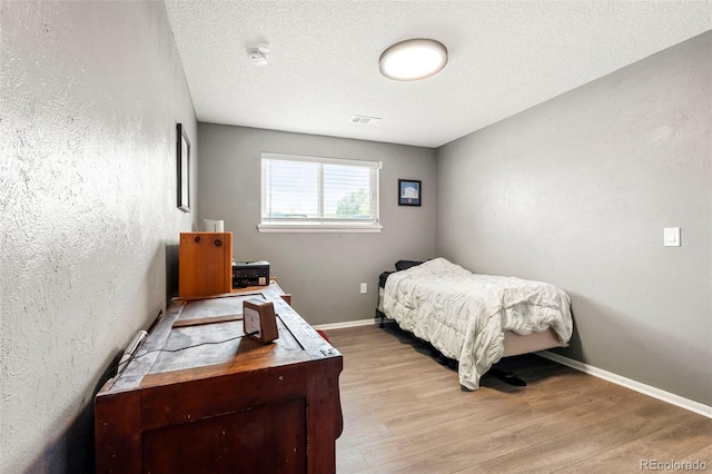 16259 W 10th Ave Unit L2, Golden, CO 80401 - bedroom featuring light wood-style floors and a textured ceiling
