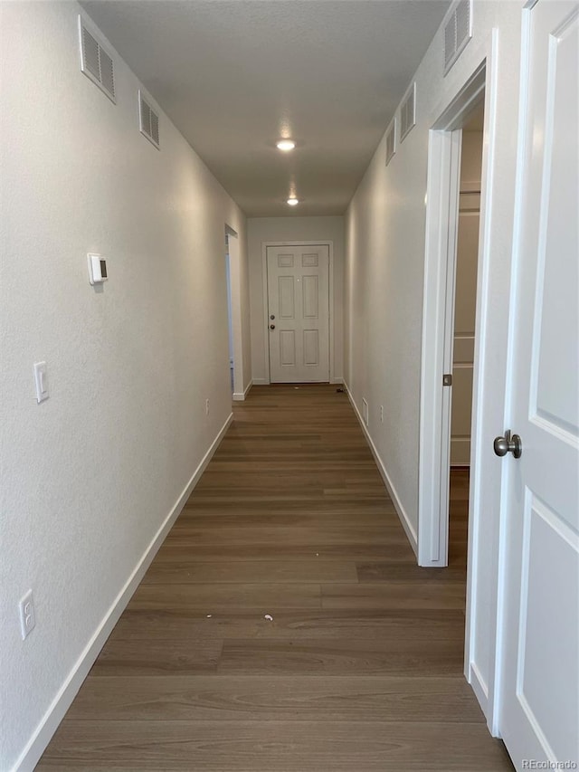 hall with baseboards and wood finished floors