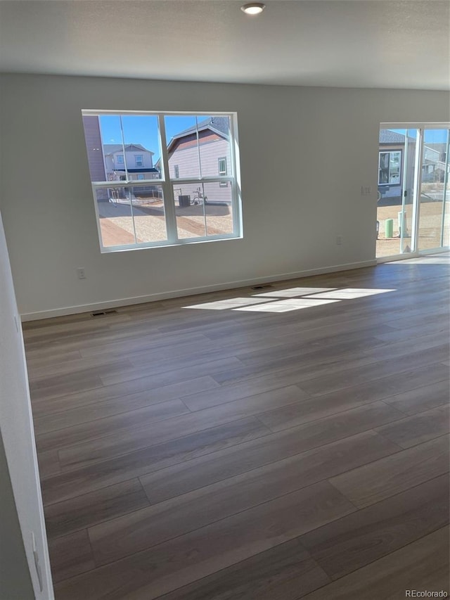 unfurnished room with wood finished floors, baseboards, and recessed lighting